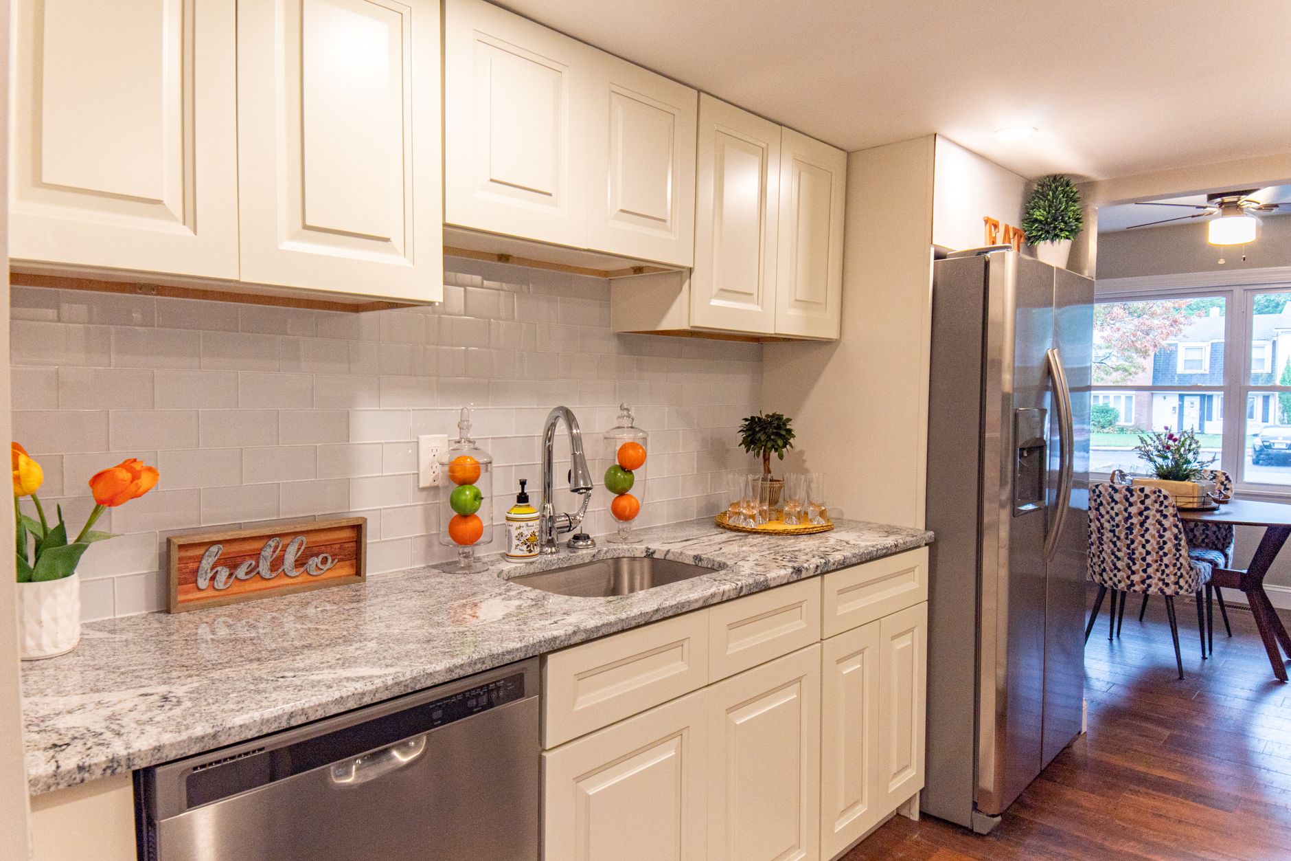 A stylish modern kitchen featuring white cabinets, granite countertops, and a stainless steel in Riverside, CA